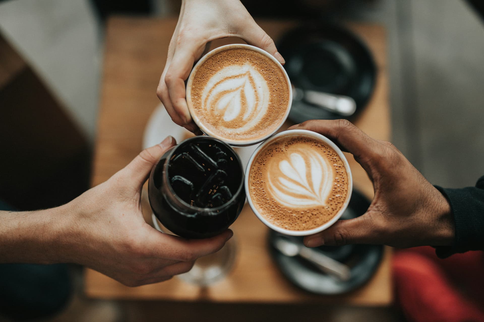 Latte art in a ceramic cup on a wooden café table