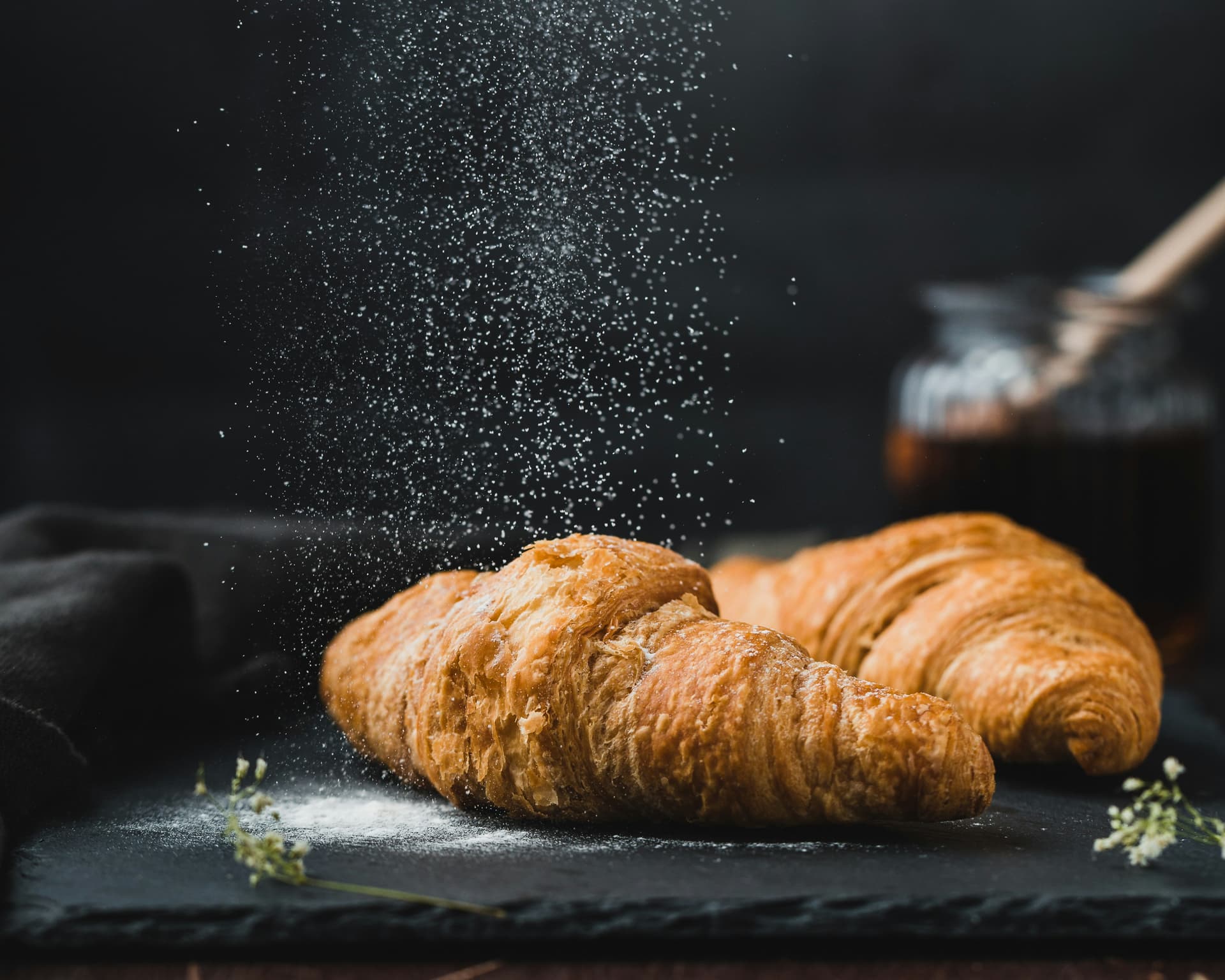 Golden croissants stacked on a cooling rack